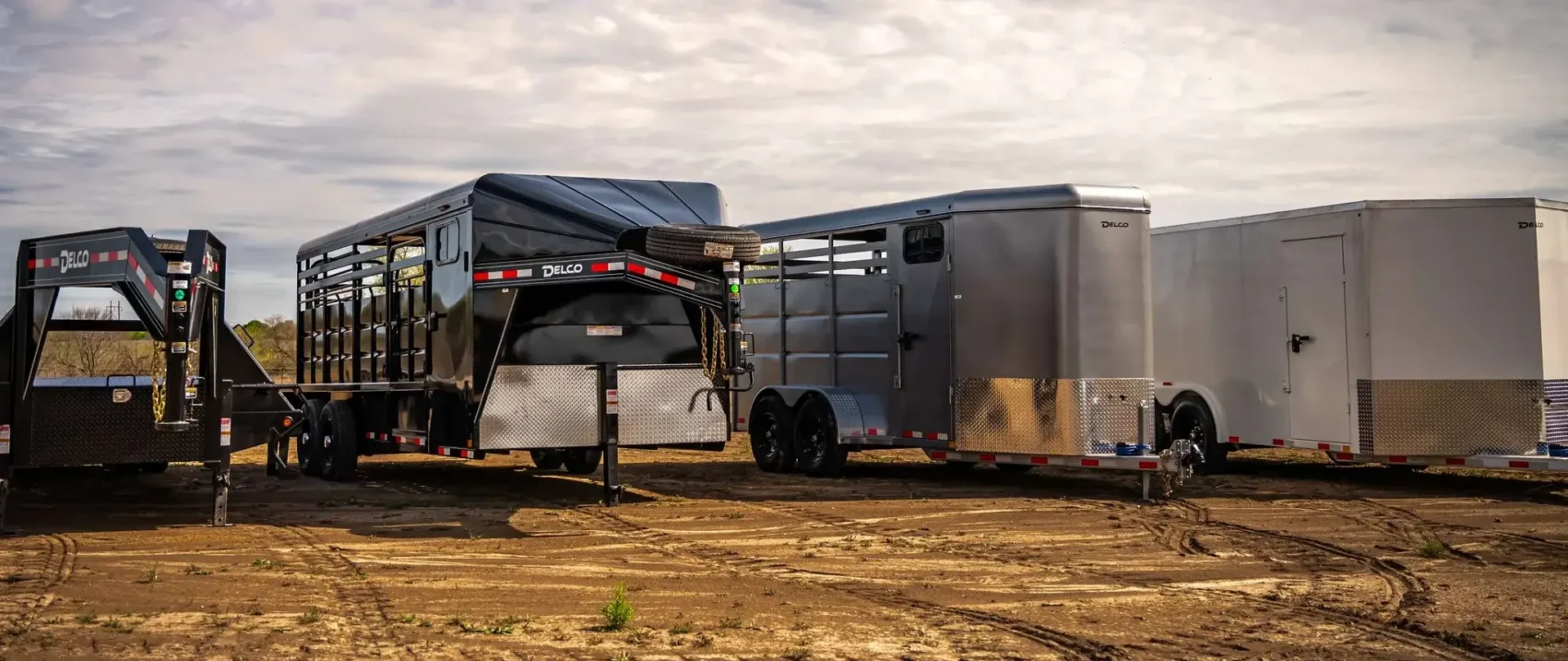 Trailers in a row on dirt.