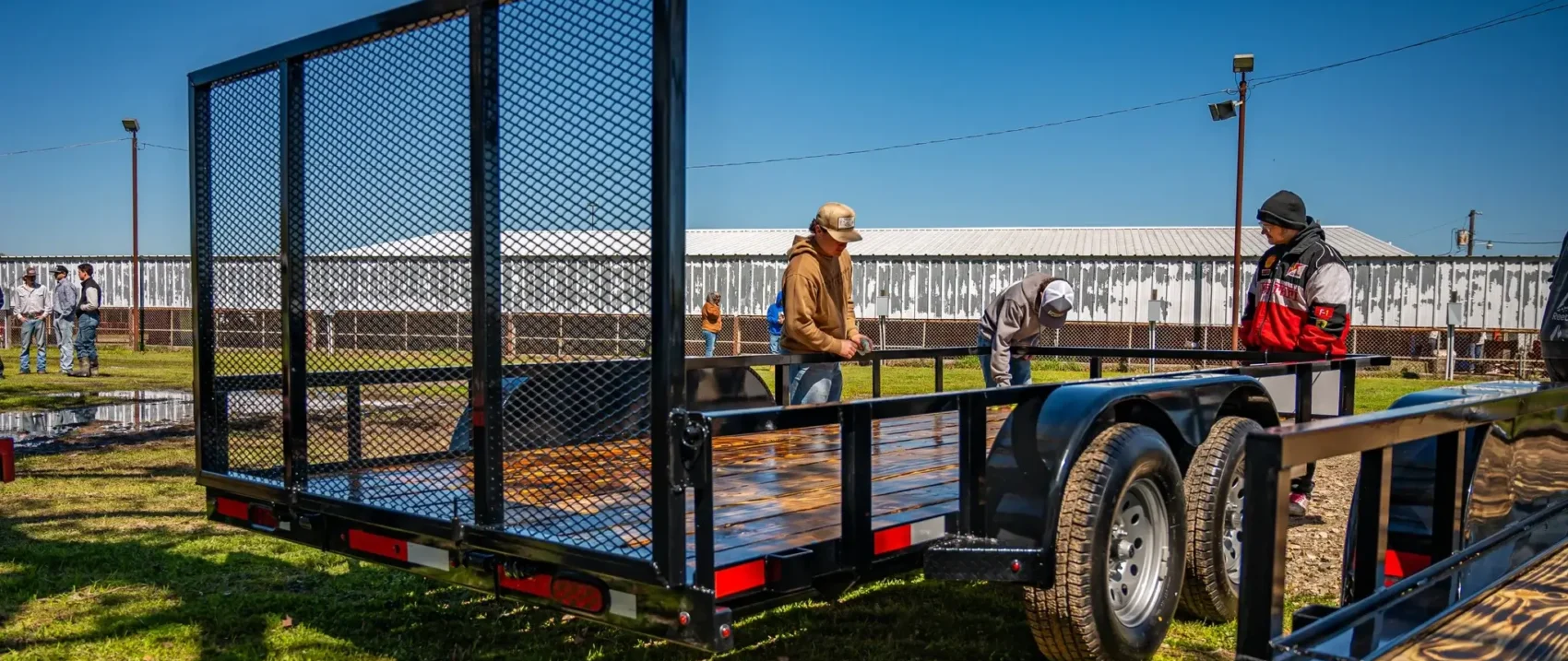 Open trailer in a field with two men.